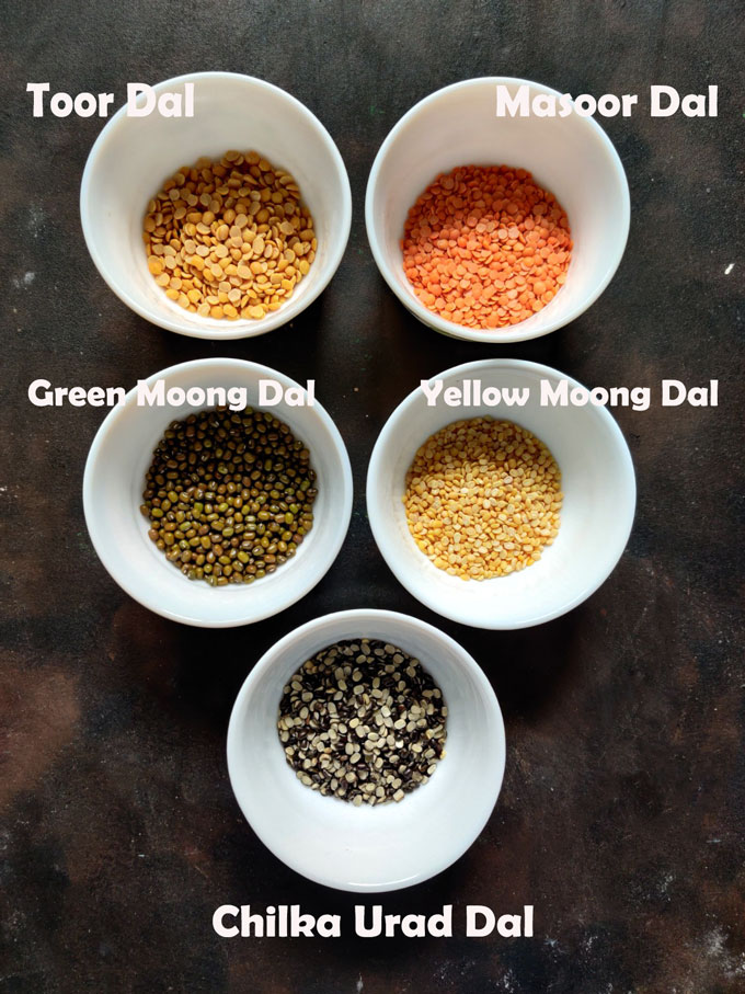 aerial shot of five lentils in bowls on a black surface