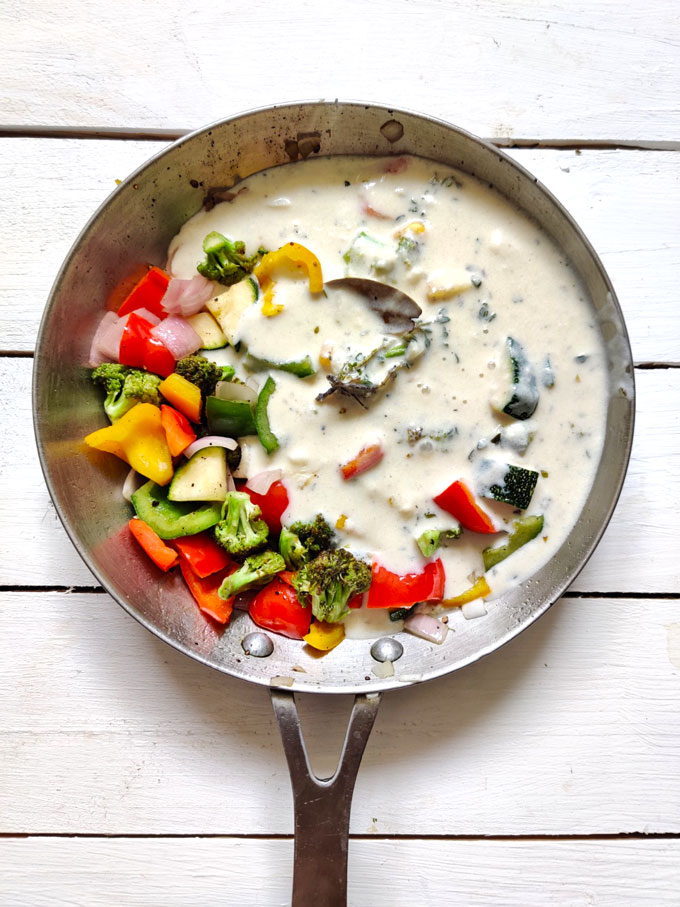 sauteed vegetables with white sauce in a pan