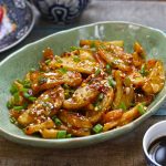 side close up shot of honey chilli potato in a green serving platter