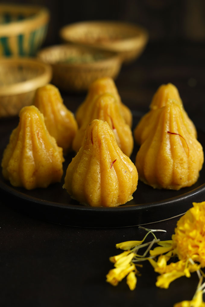 close up side shot of khoya modak on a black platter