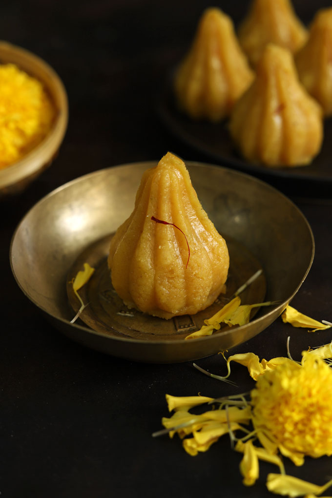 close up side shot of modak on a brass serving bowl