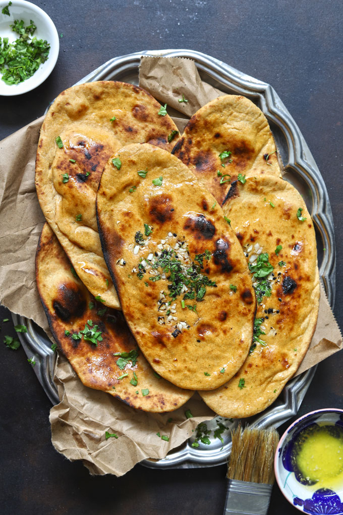 aerial shot of whole wheat naan without yeast stacked on a brown parchment paper