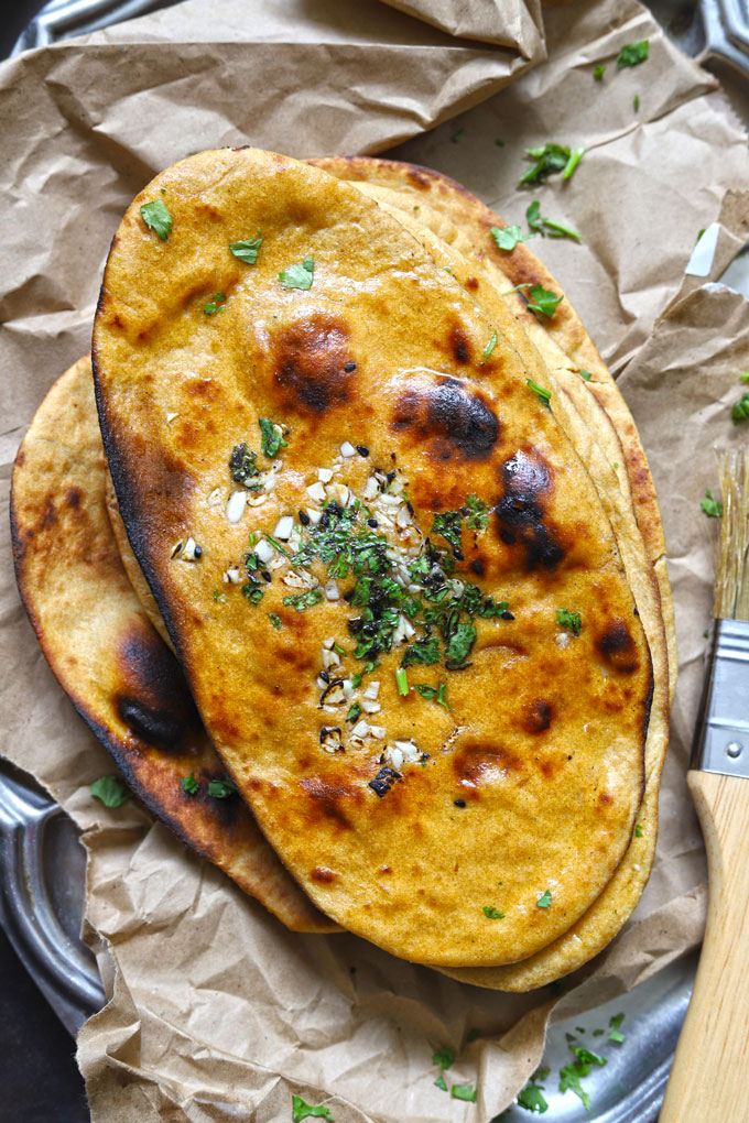 aerial shot of whole wheat naan without yeast stacked on a brown parchment paper