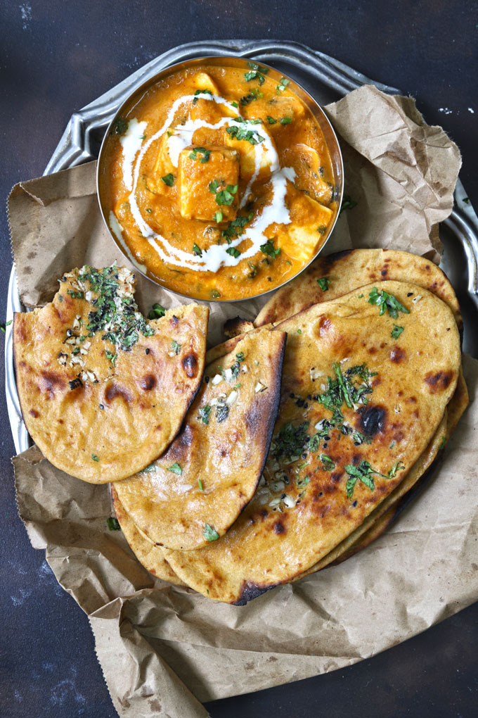 aerial shot of naan and paneer makhani on a steel platter