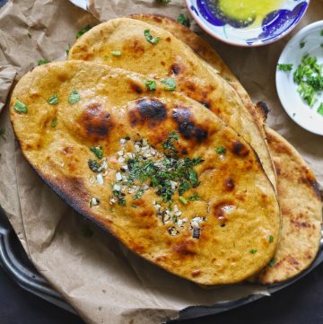 aerial shot of whole wheat tawa naan stacked on a brown parchment paper