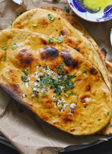 aerial shot of whole wheat tawa naan stacked on a brown parchment paper