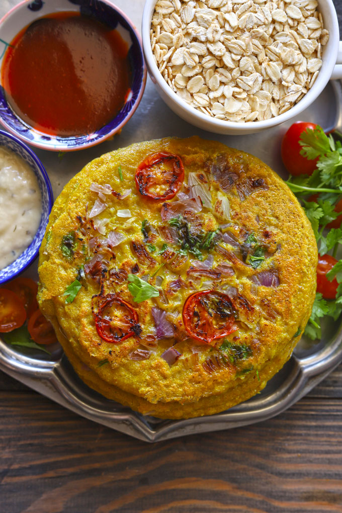 close up aerial shot of moong dal chilla stacked on a platter