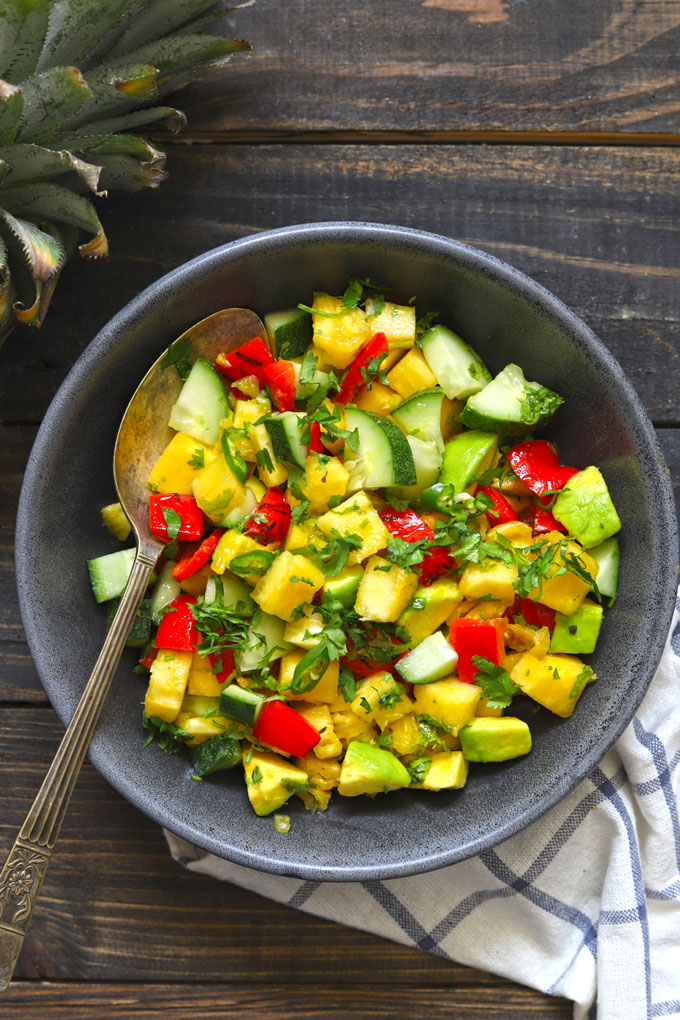 aerial shot of tropical pineapple salsa in a black ceramic bowl