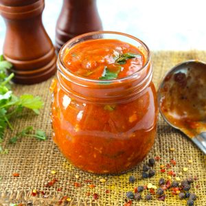 side shot of homemade pizza sauce in a glass bottle