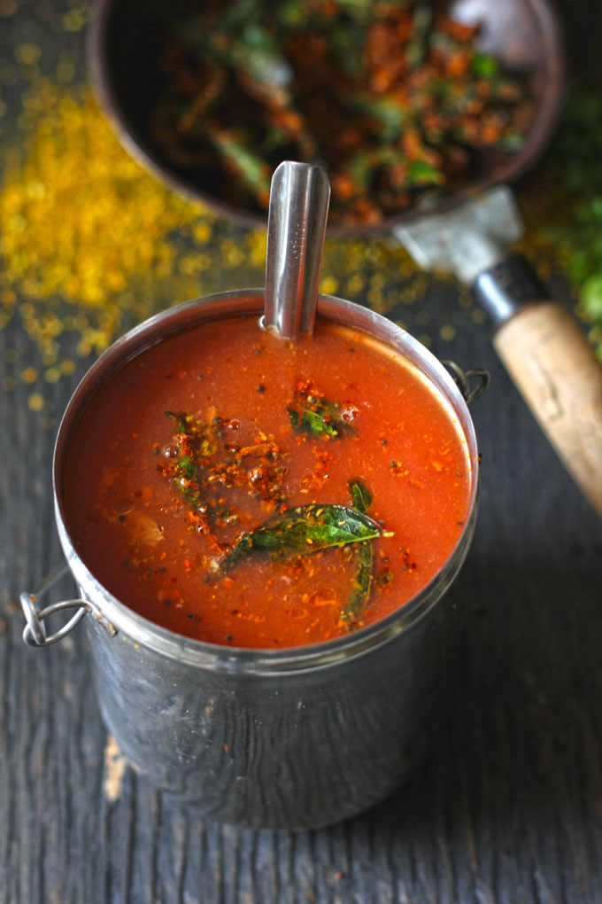 side shot of tomato garlic rasam in a stainless steel container