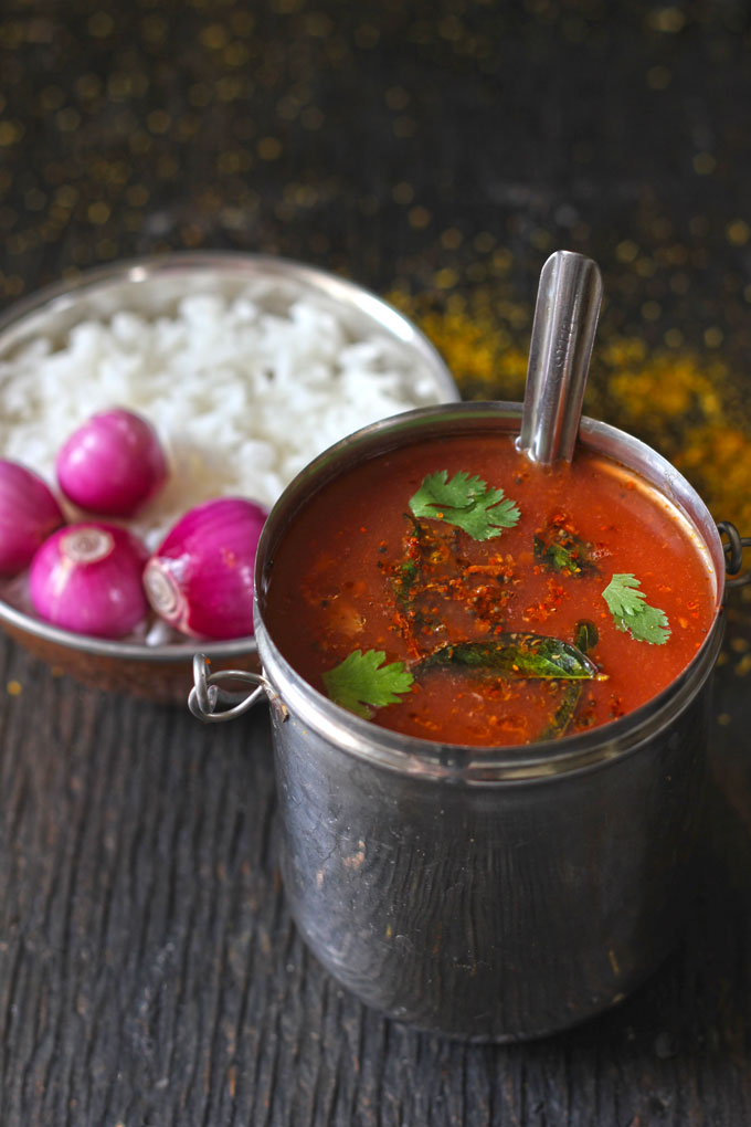 side shot of tomato garlic rasam in a stainless steel container