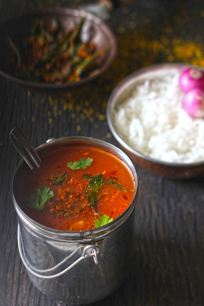 side shot of tomato garlic rasam recipe in a stainless steel container