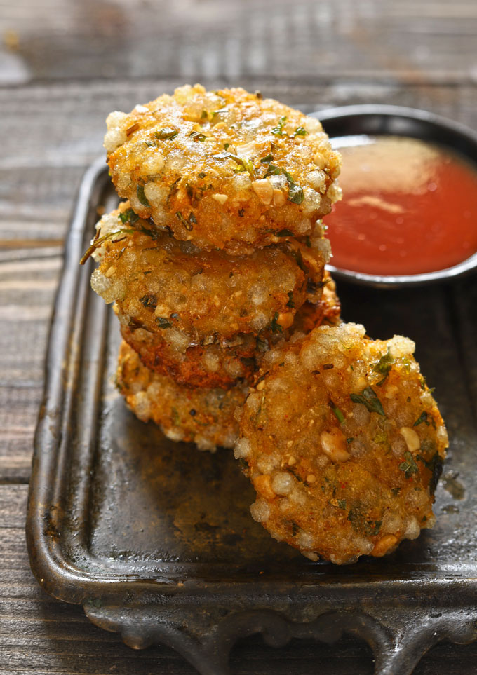 side shot of sabudana vada stacked on a black tray