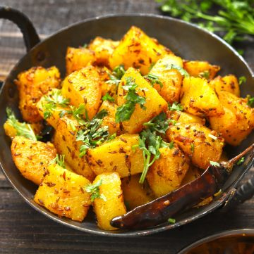 side close up shot of aloo gutuk in a cast iron skillet