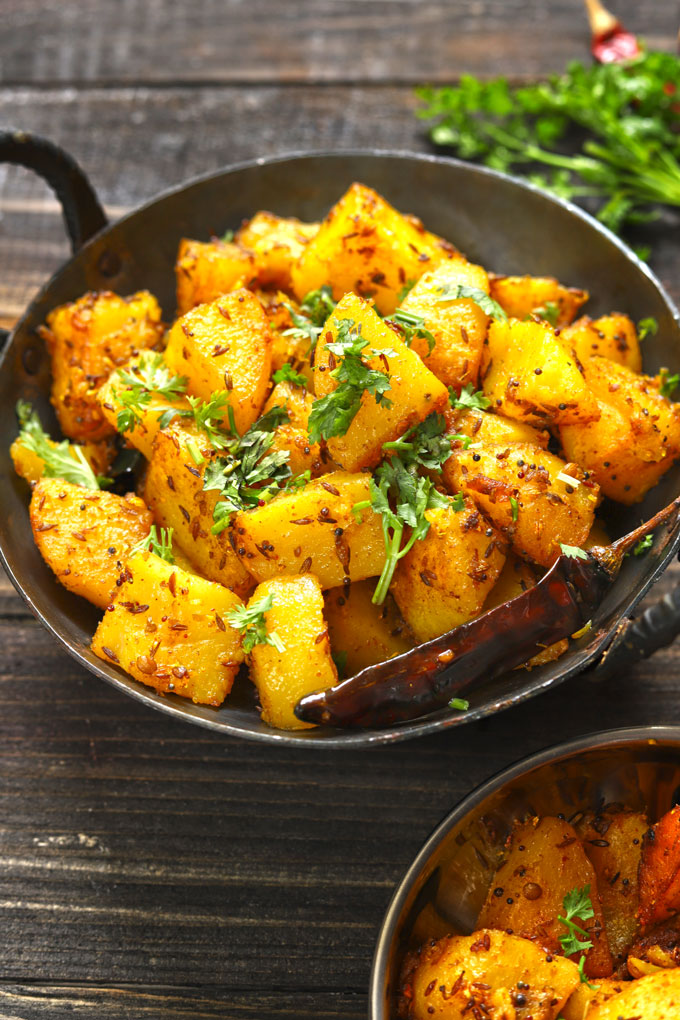 side shot of aloo gutuk in a cast iron skillet