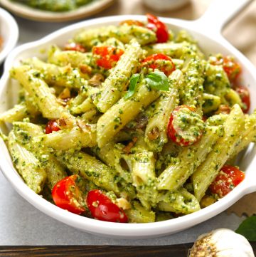 side close up shot of basil pesto pasta in a white pan