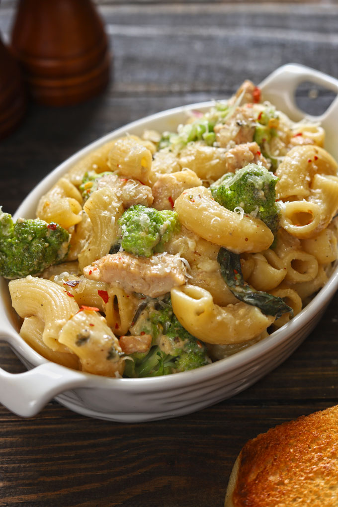 side close up shot of broccoli pasta in a white ceramic baking dish