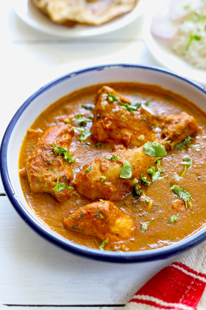 side shot of Indian chicken curry in a white serving bowl