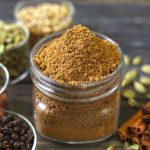 side close up shot of homemade garam masala in a glass bottle