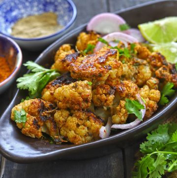 side close up shot of tandoori gobi in a black platter