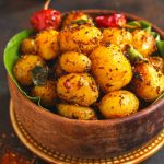 side shot of Indian masala potato roast in a wooden bowl