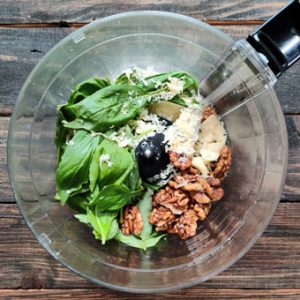 making basil pesto sauce in a food processor