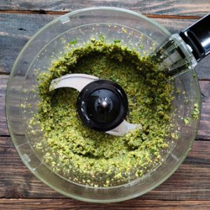 making basil pesto sauce in a food processor