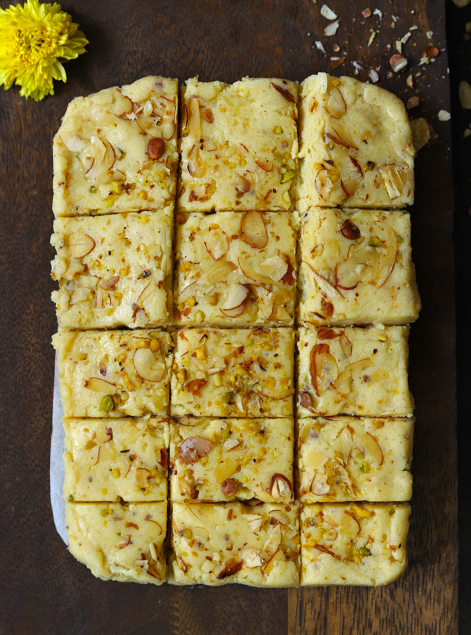 aerial shot of khoye ki barfi arranged on a brown wooden platter