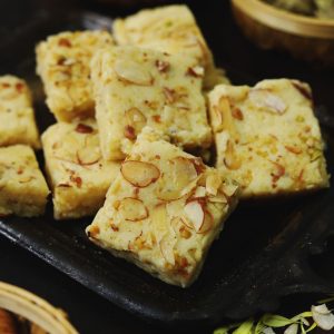 side close up shot of mawa barfi arranged on a black tray