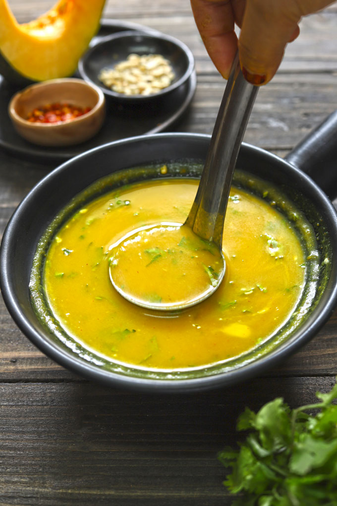 aerial shot of curried pumpkin soup in a black serving bowl