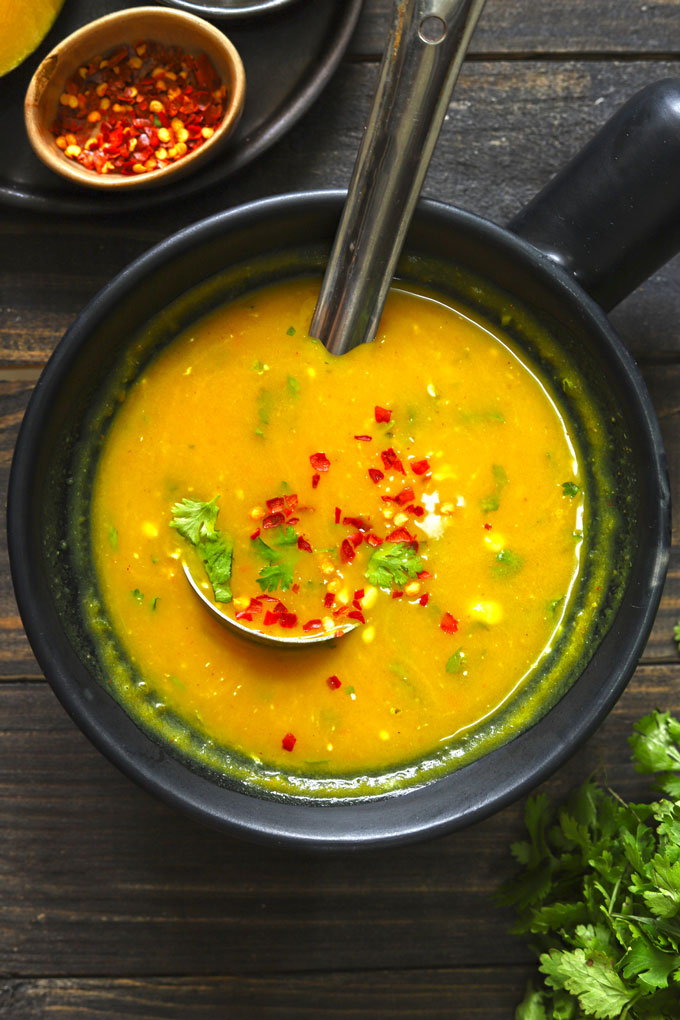 aerial shot of pumpkin soup in a black serving bowl