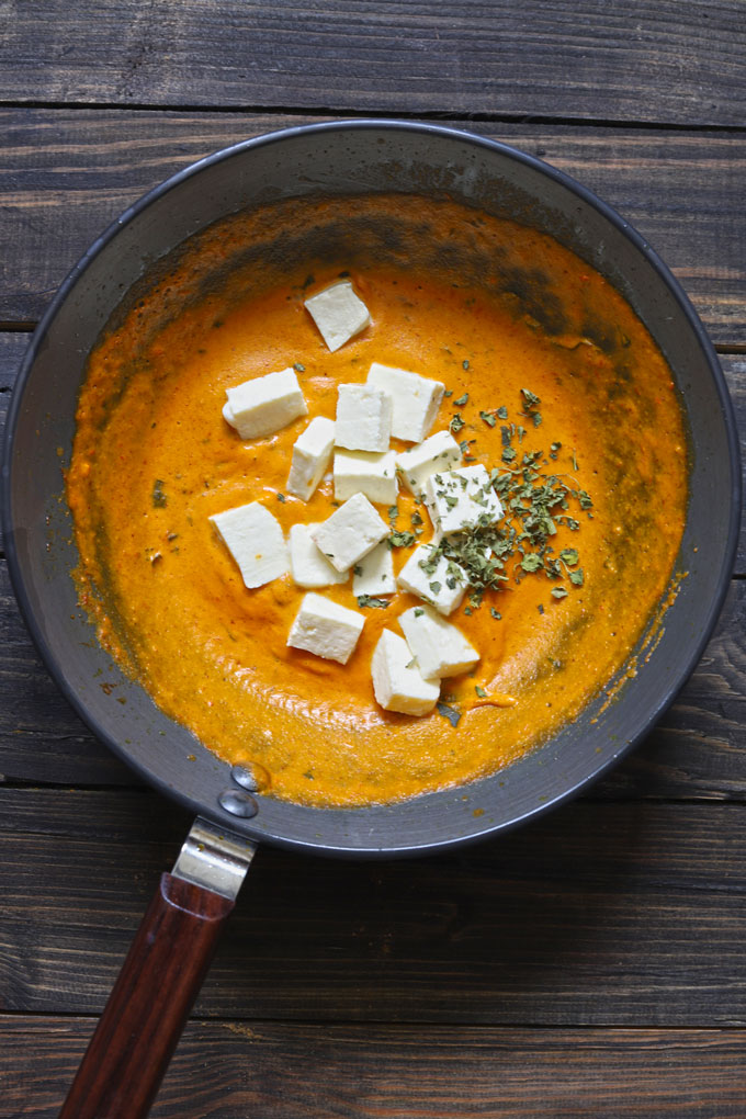 aerial shot of paneer in a rich makhani gravy on a black wok