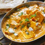 side close up shot of paneer makhani in a copper serveware