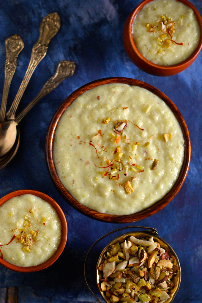 aerial shot of phirni in a wooden bowl garnished with nuts and saffron