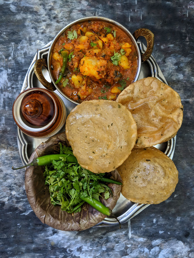 aerial shot of aloo ki sabzi and poori in a plate