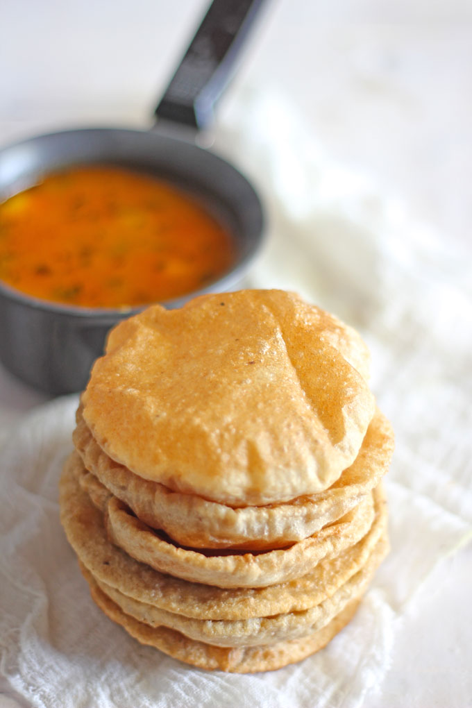 side close up shot of stacked poori on a white background