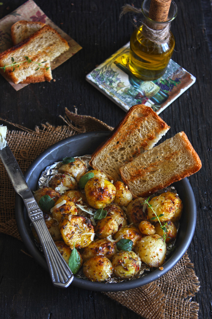 aerial shot of roasted potato in a black bowl with slices of bread