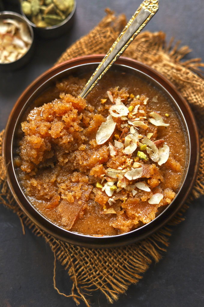 aerial shot of suji ka halwa with spoon in a stainless steel bowl