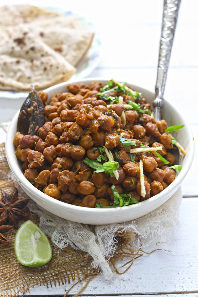 side close up shot of chana masala in a white ceramic bowl