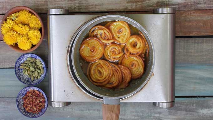 soaking jalebi in sugar syrup