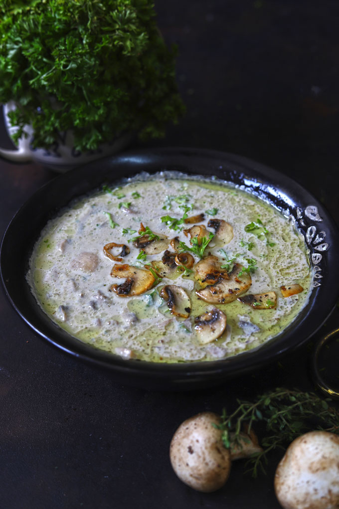 side shot of healthy mushroom soup in a black bowl