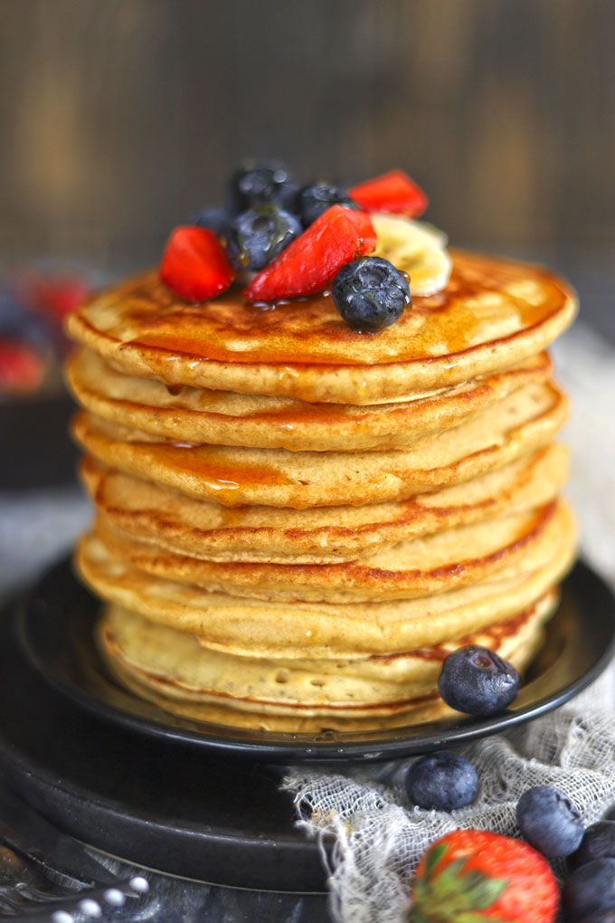 side shot of whole wheat pancakes stacked on a plate