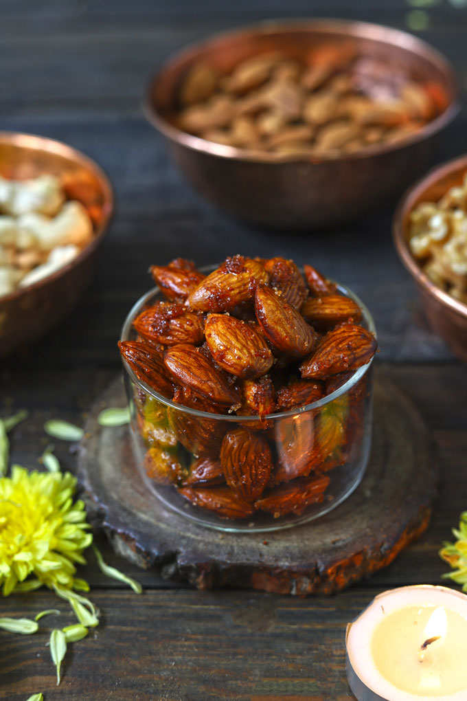 side close up shot of honey spiced almonds in a glass bowl