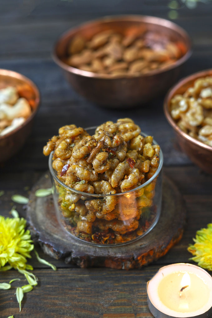 side close up shot of roasted walnuts in a glass bowl