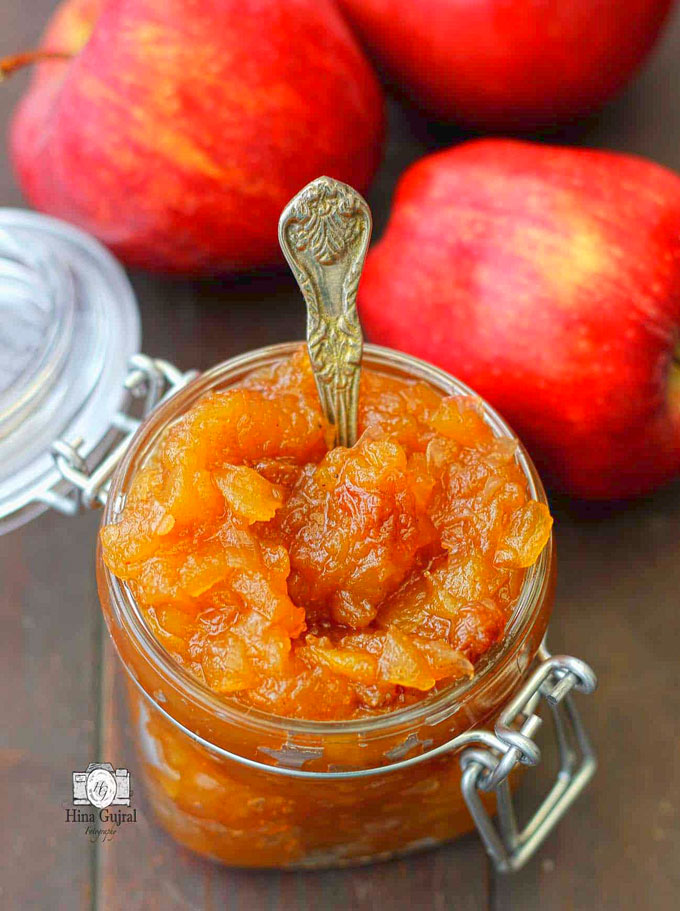 side shot of savory apple chutney in a glass jar with a spoon