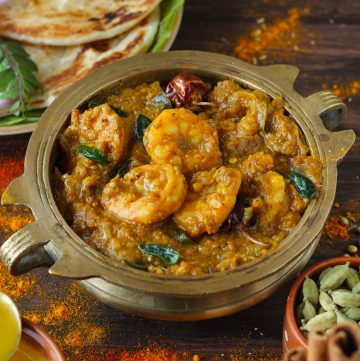 side shot of Chettinad prawn curry served in a tradtional serveware