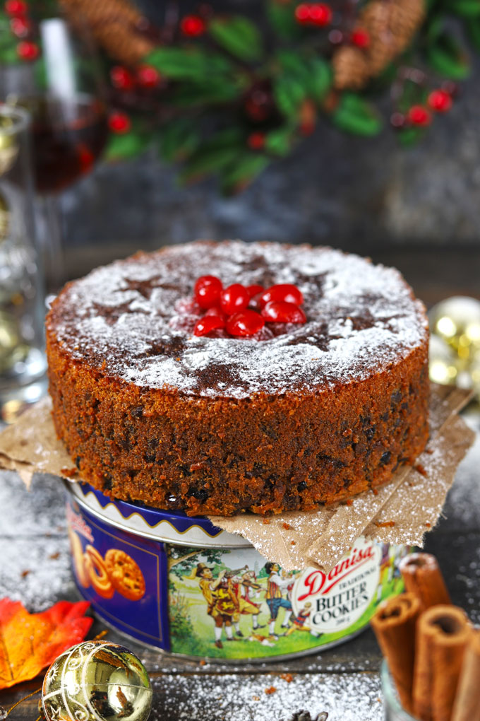 side shot of Christmas fruit cake on top of a cookie box