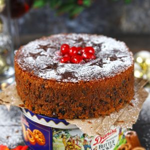 side shot of Christmas fruit cake on top of a cookie box