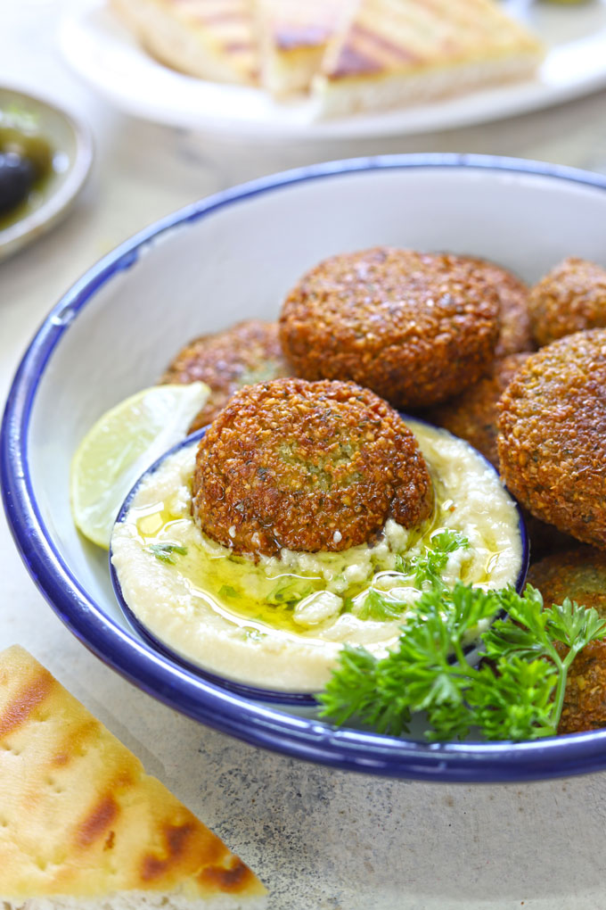 side close up shot of falafel dipped in hummus