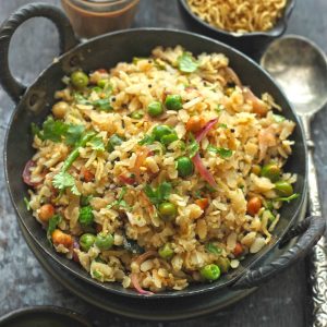 side close up shot of matar poha on a black kadhai